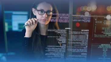 Female data analyst looks at computer codes on desktop.